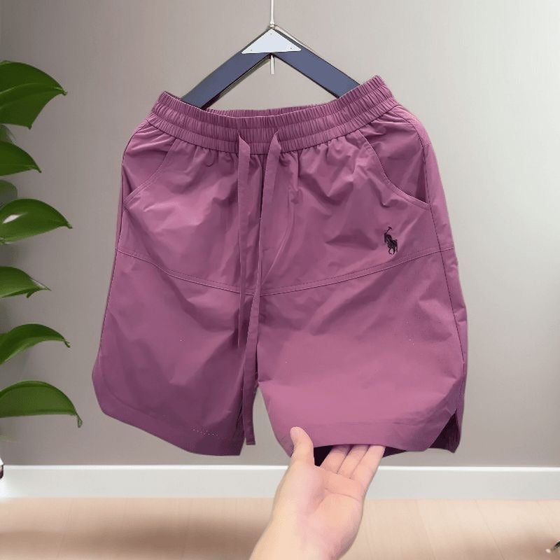 Nuevos pantalones cortos casuales transpirables perforados con láser para hombre en verano, pantalones de seda de hielo rápido y sueltos y sueltos de cinco puntos