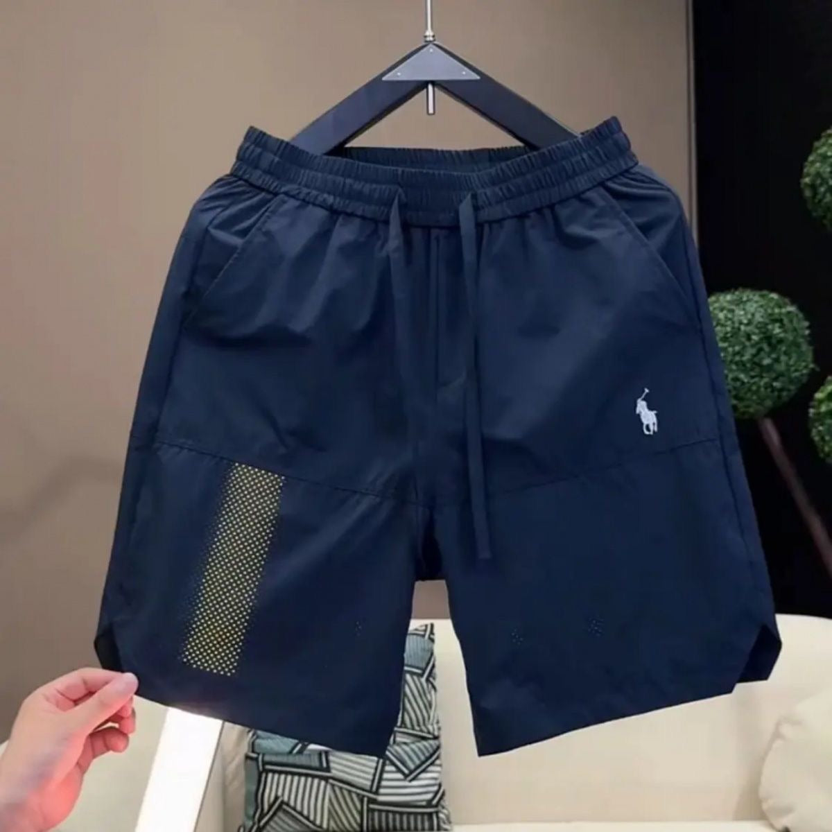 Nuevos pantalones cortos casuales transpirables perforados con láser para hombre en verano, pantalones de seda de hielo rápido y sueltos y sueltos de cinco puntos