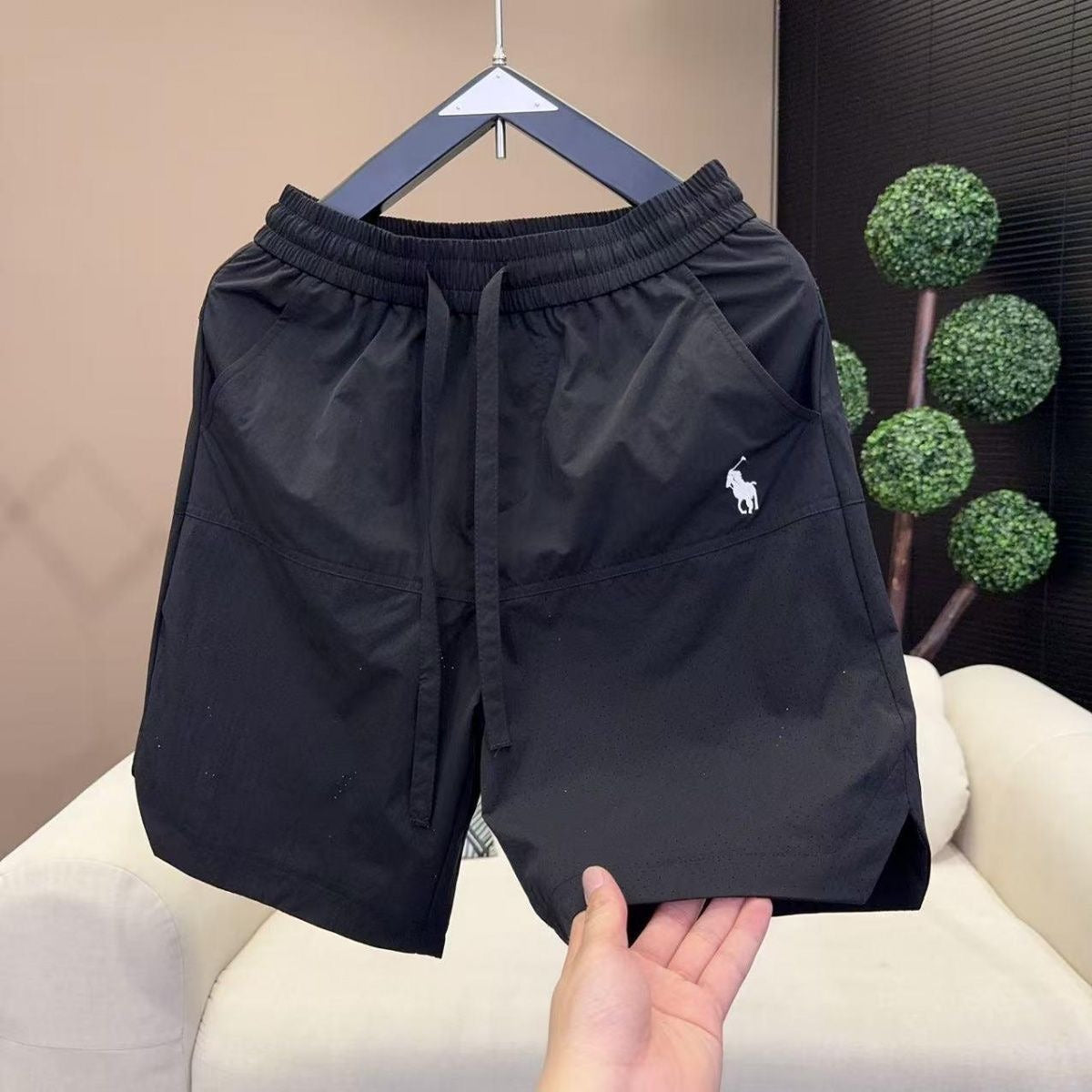 Nuevos pantalones cortos casuales transpirables perforados con láser para hombre en verano, pantalones de seda de hielo rápido y sueltos y sueltos de cinco puntos