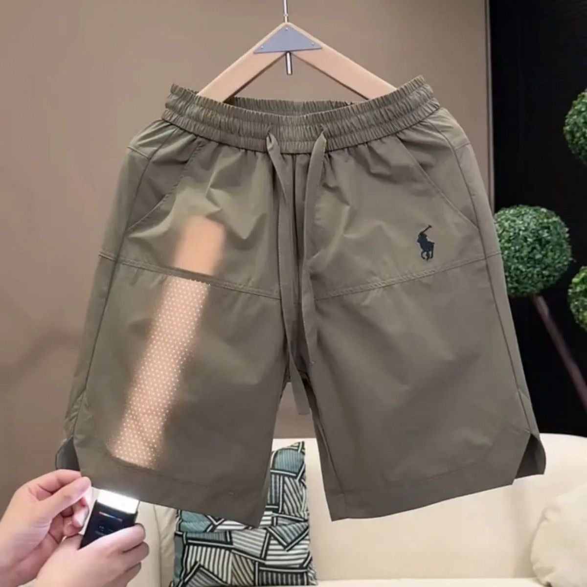 Nuevos pantalones cortos casuales transpirables perforados con láser para hombre en verano, pantalones de seda de hielo rápido y sueltos y sueltos de cinco puntos