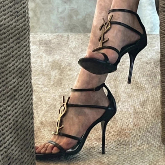 Sandalias de mujer de un solo tirante, nuevos y sexys tacones de tacón de aguja negros con tacones de aguja con botón de letra versátiles y sexy 2026